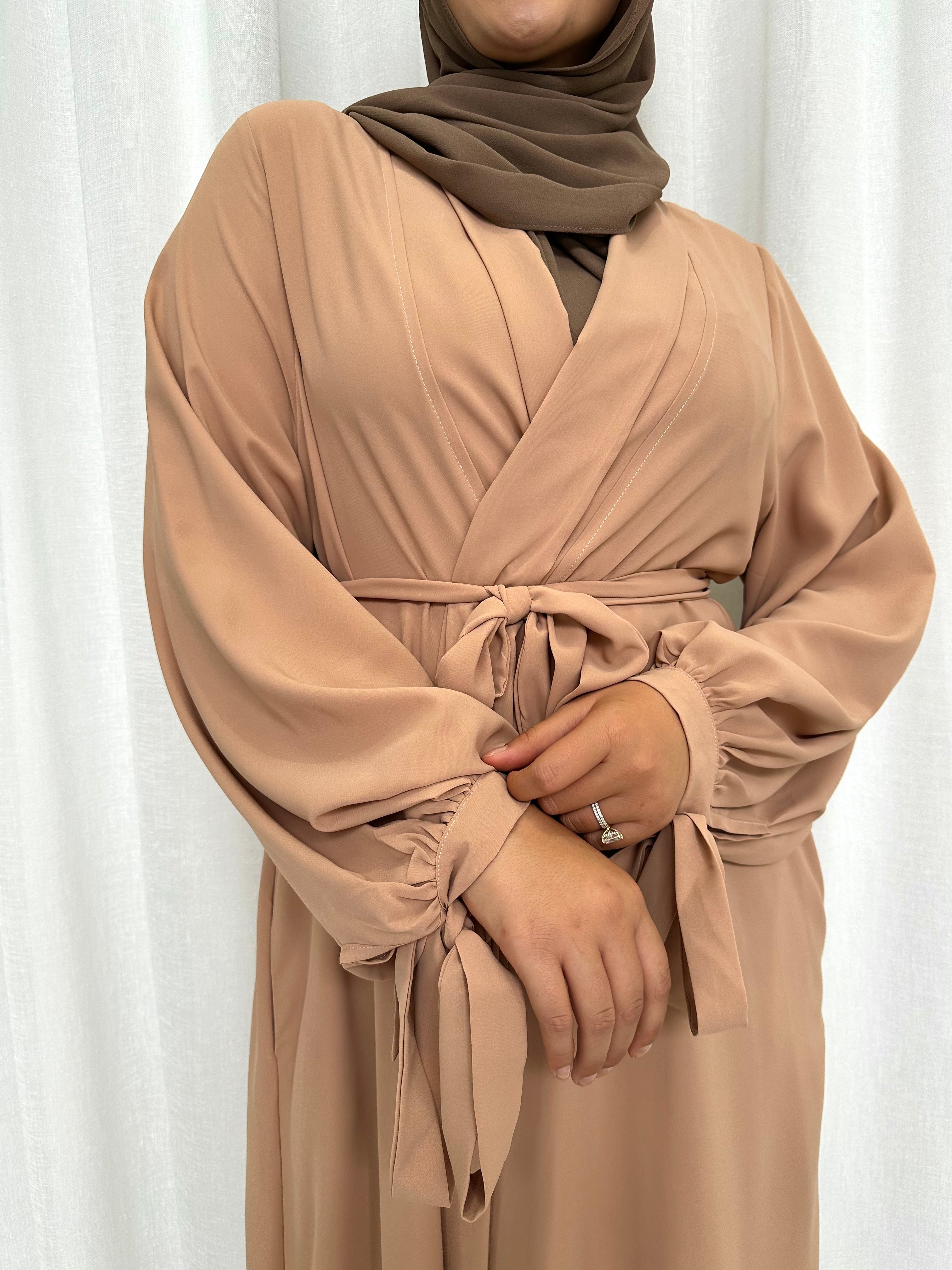 It's made from polyester, designed for a loose fit on the body and has long balloon sleeves with shirred tie cuffs then drops to a floor length.