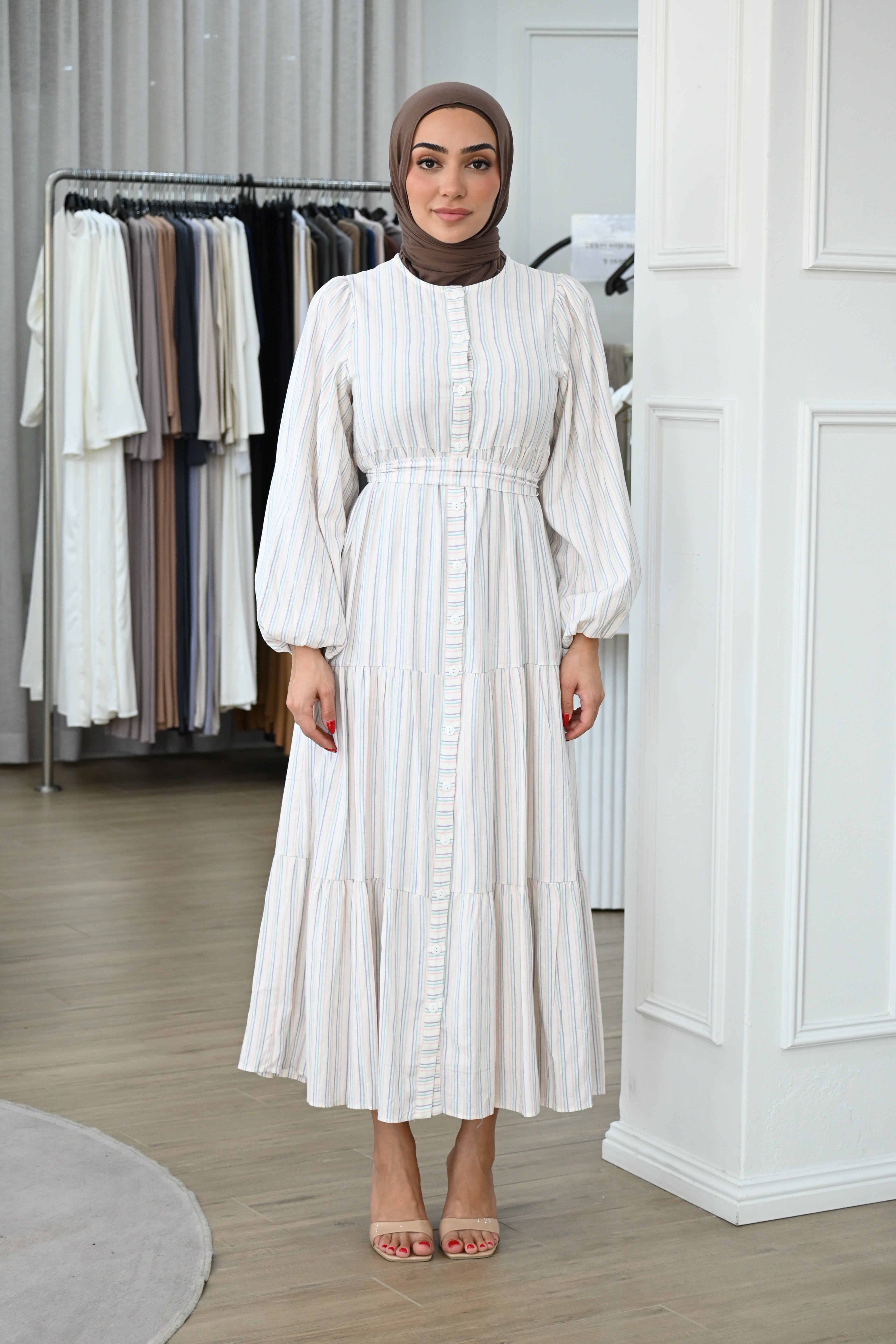 Designed with a button-down front, gathered waist, and tiered skirt, it flows beautifully with every step. Fully lined polyester fabric.