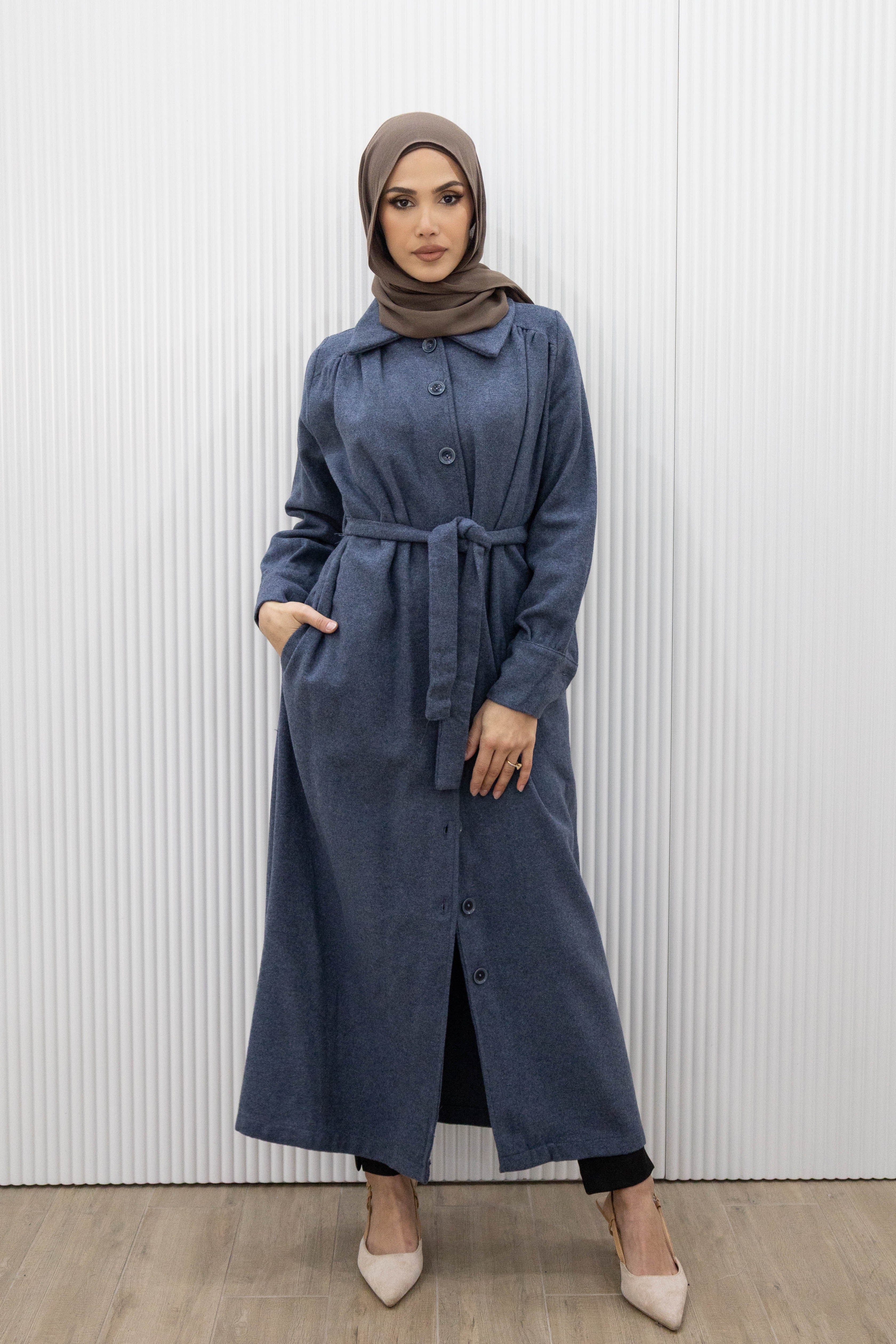 This buttoned maxi coat not only exudes elegance, but also offers practicality with a detachable waist tie for a fitted look. The wide collar and long sleeves with buttoned cuffs complete the full length silhouette, keeping you warm and stylish all season long.