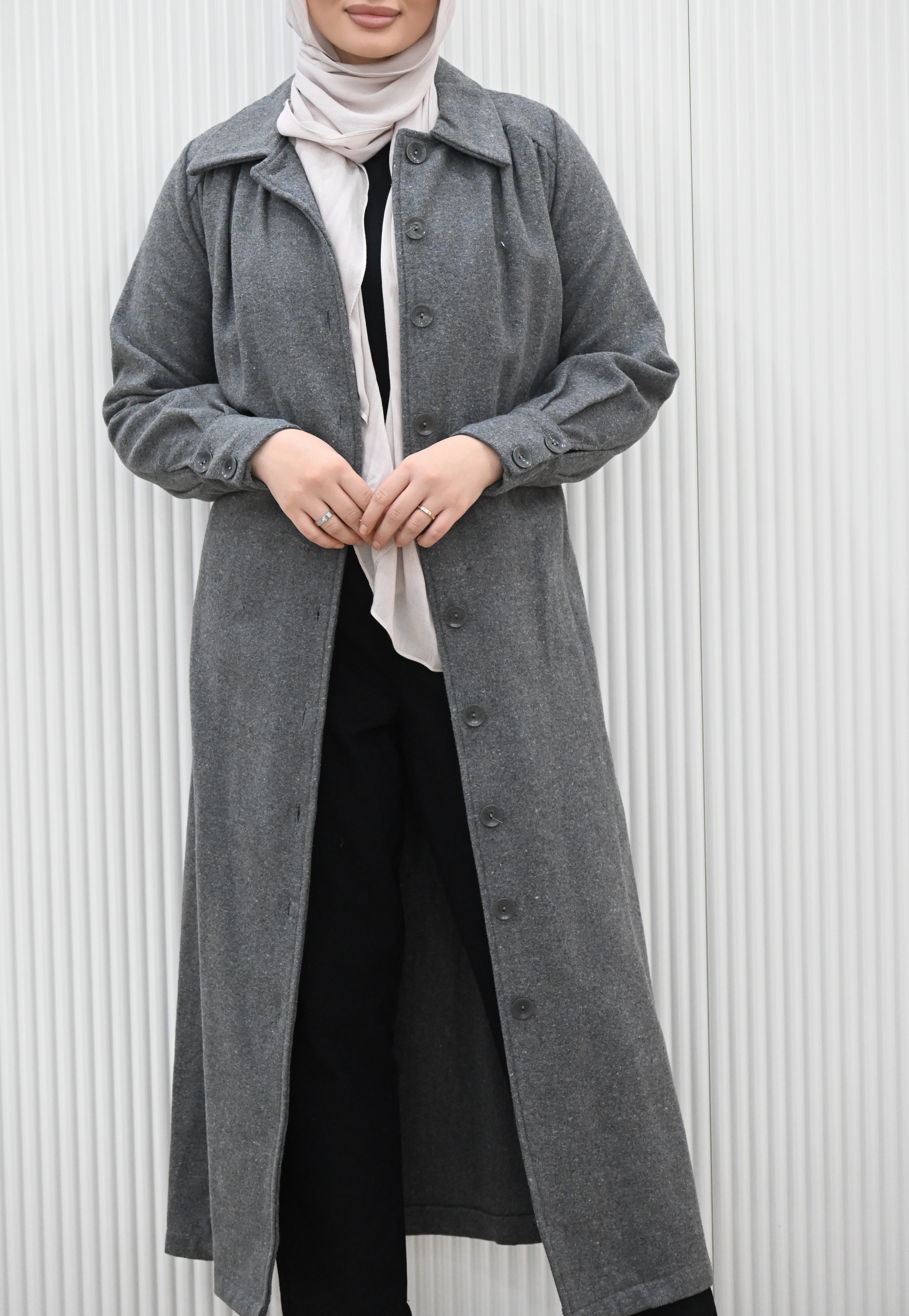 This buttoned maxi coat not only exudes elegance, but also offers practicality with a detachable waist tie for a fitted look. The wide collar and long sleeves with buttoned cuffs complete the full length silhouette, keeping you warm and stylish all season long.