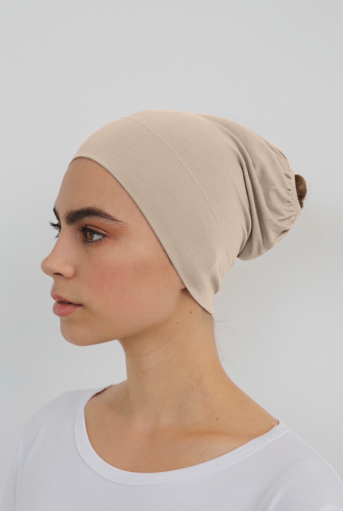 Bamboo under-scarf cap designed to cover hair beneath a hijab, made from soft, breathable natural bamboo fibers with cotton spandex stretch for comfort. Partially closed at the back with an elastic edge to comfortably accommodate hair.
