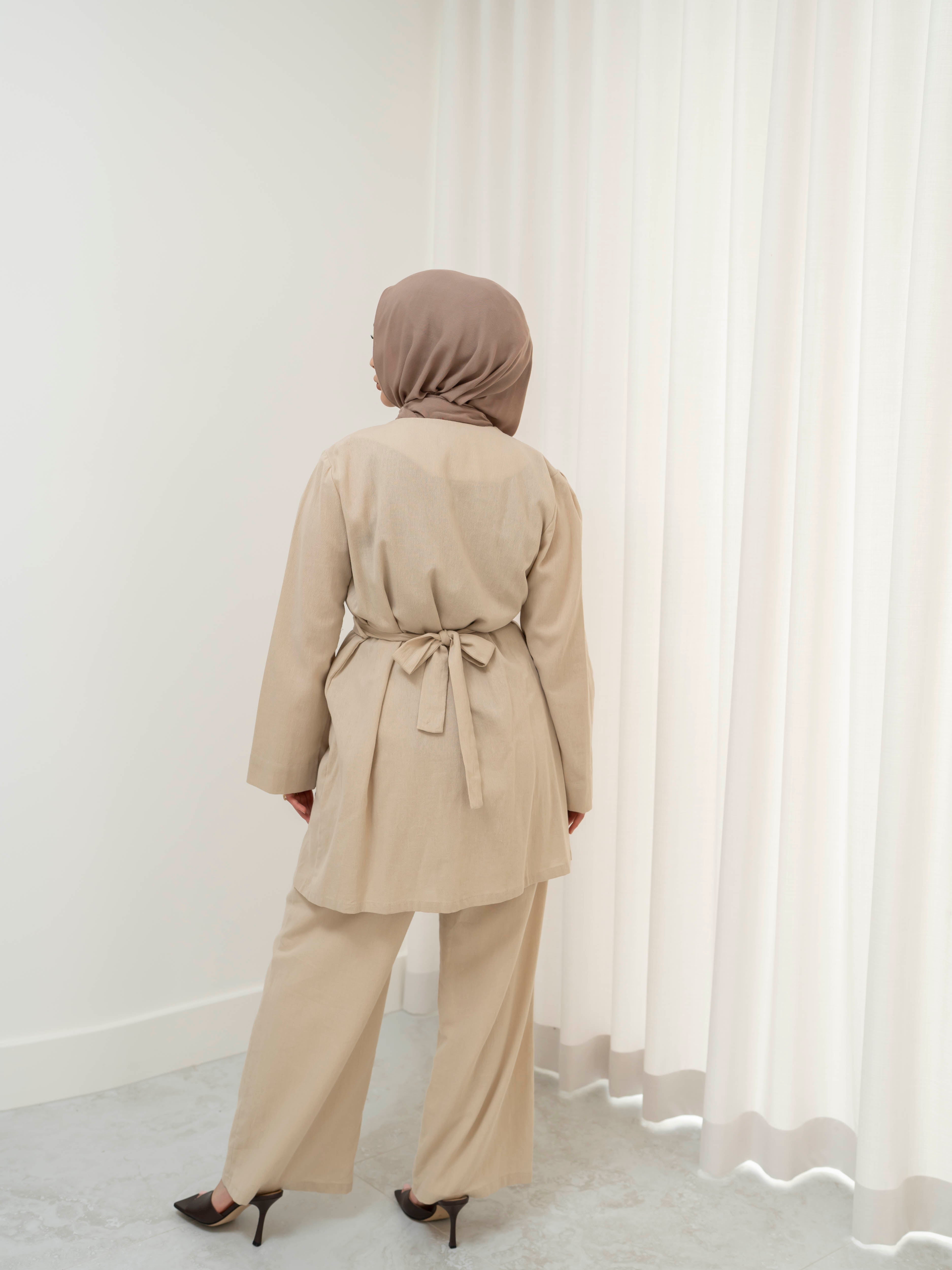 Raya Tailored Set, a two-piece outfit with a belted tailored jacket featuring structured lapels and matching wide-leg pants with elasticated waistband. Full-length, modest silhouette in lightweight fabric with refined drape, ideal for Eid, formal occasions, or elevated everyday wear.