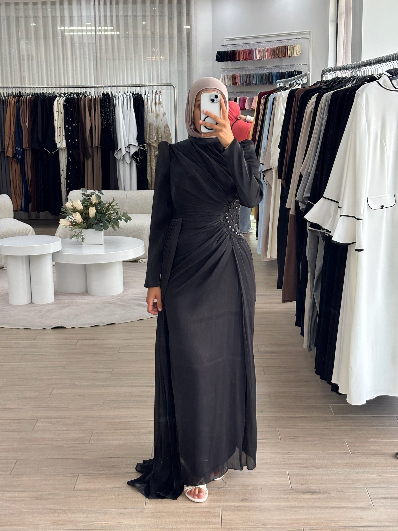 Reanne Formal Dress in glossy satin with a flattering ruched silhouette, high neckline, and long sleeves. Features embellished waist detailing, a draped floor-length panel, invisible back zip, and full lining — perfect for elegant formal occasions.