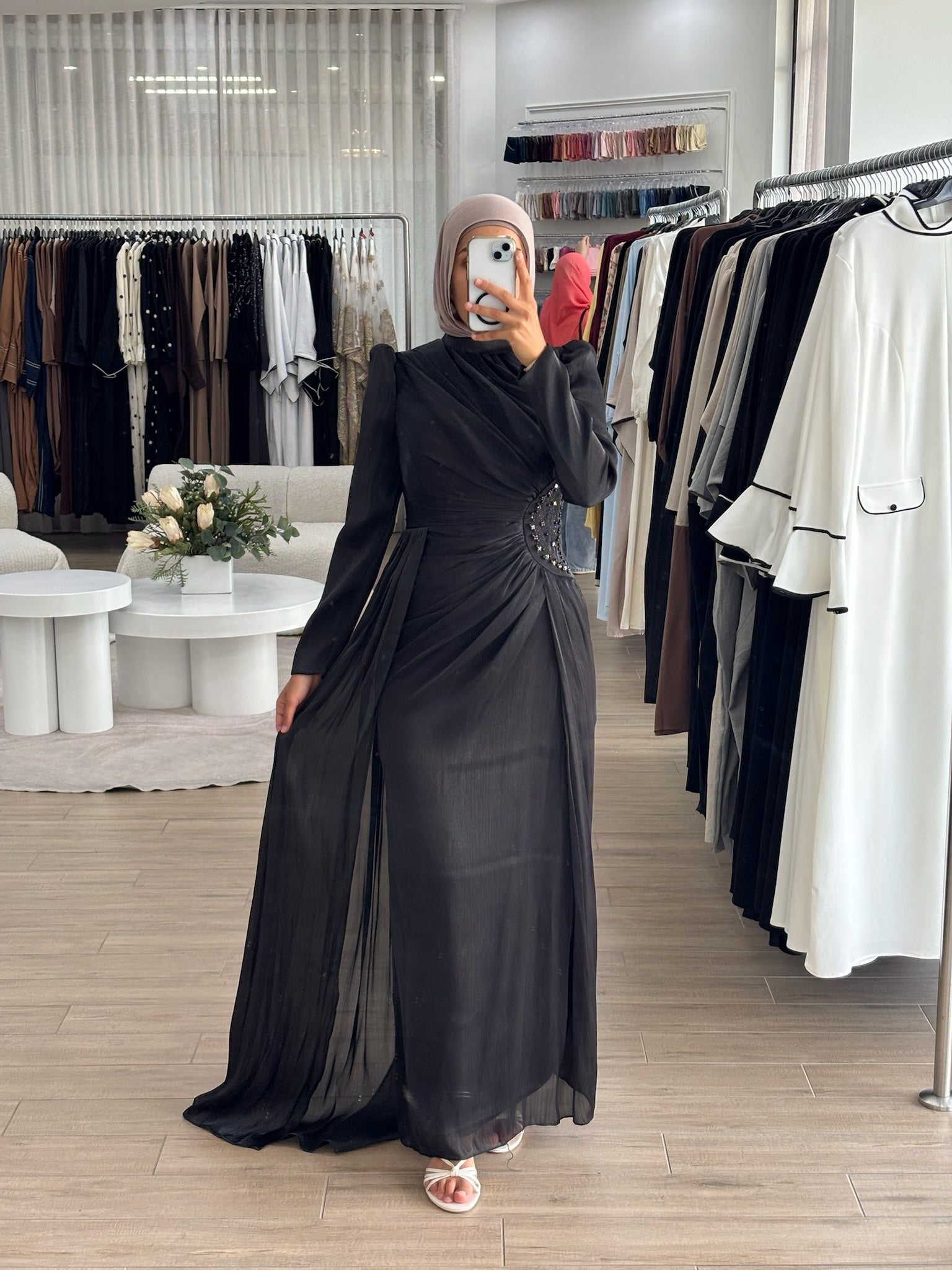 Reanne Formal Dress in glossy satin with a flattering ruched silhouette, high neckline, and long sleeves. Features embellished waist detailing, a draped floor-length panel, invisible back zip, and full lining — perfect for elegant formal occasions.