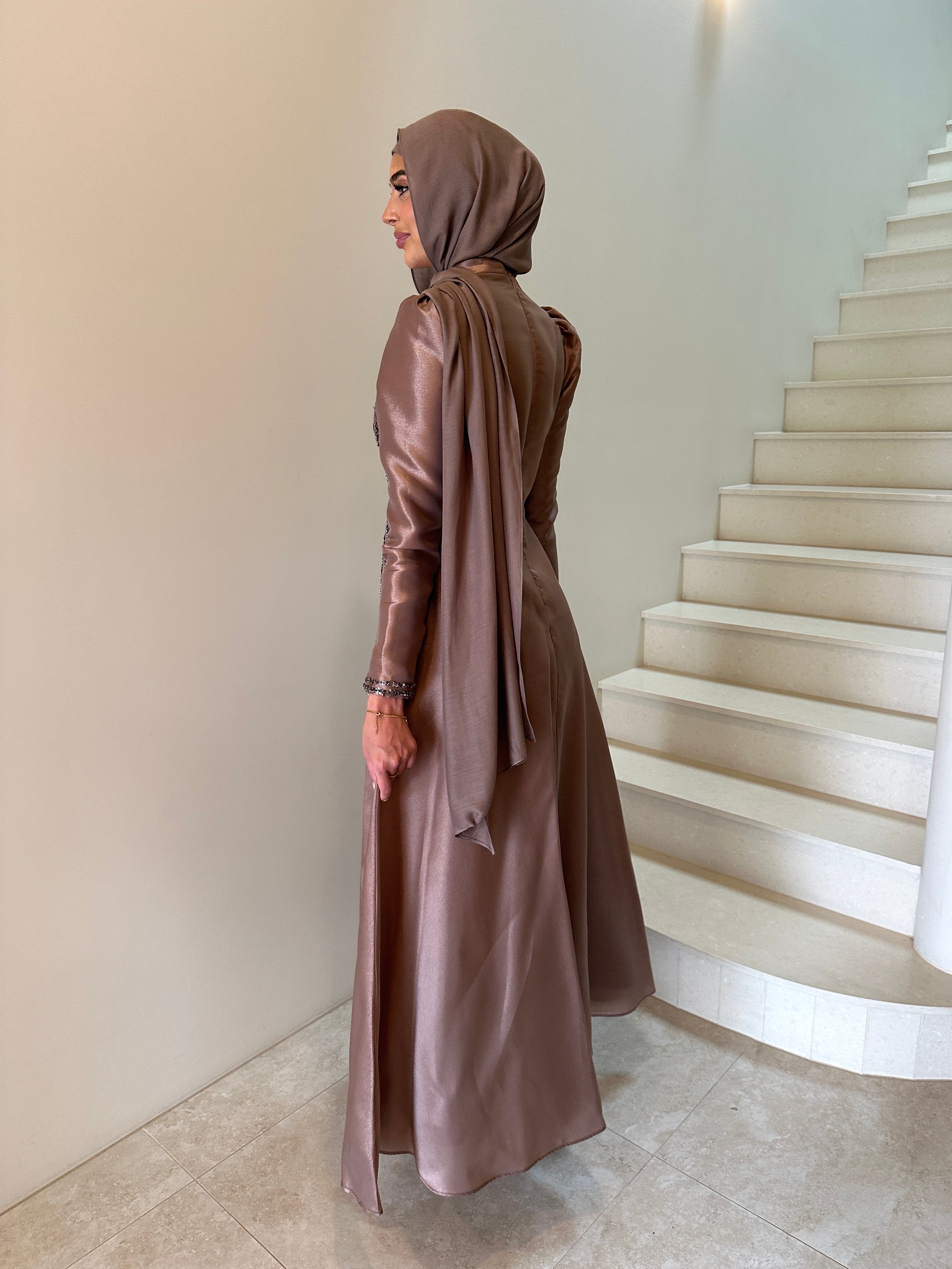 Shaima Formal Dress in shiny satin with a fitted waist and ball gown skirt. Features high neck, puffy shoulders, long sleeves, and sequined embellishments on bodice and skirt with an invisible back zip — perfect for formal occasions.