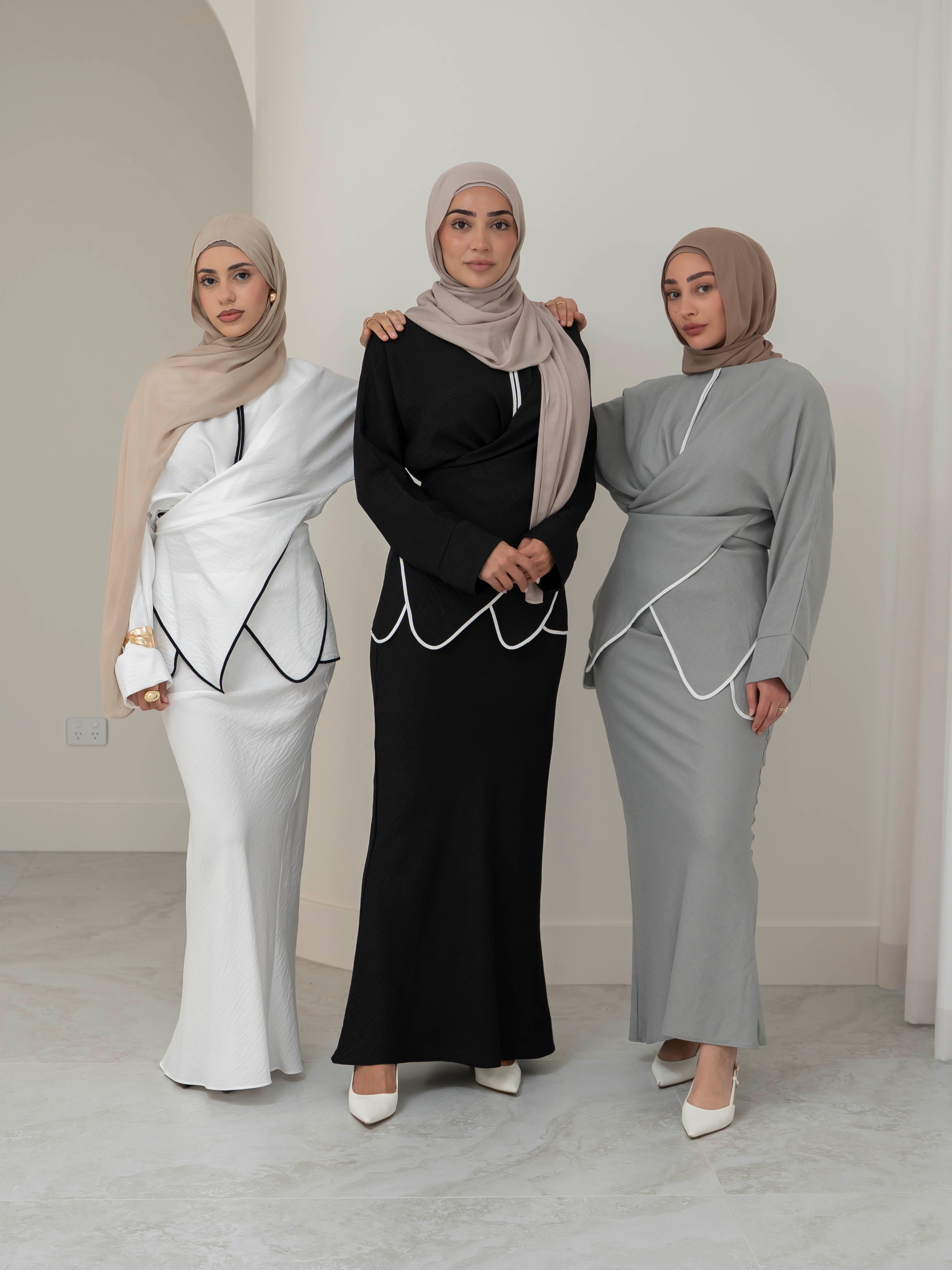 Sienna Wrap Set, a two-piece outfit with a wrap-style tie top featuring contrast piping and long sleeves, paired with a full-length flowing skirt. Lightweight fabric drapes elegantly for a modest, refined silhouette suitable for Eid, special occasions, or versatile everyday wear.