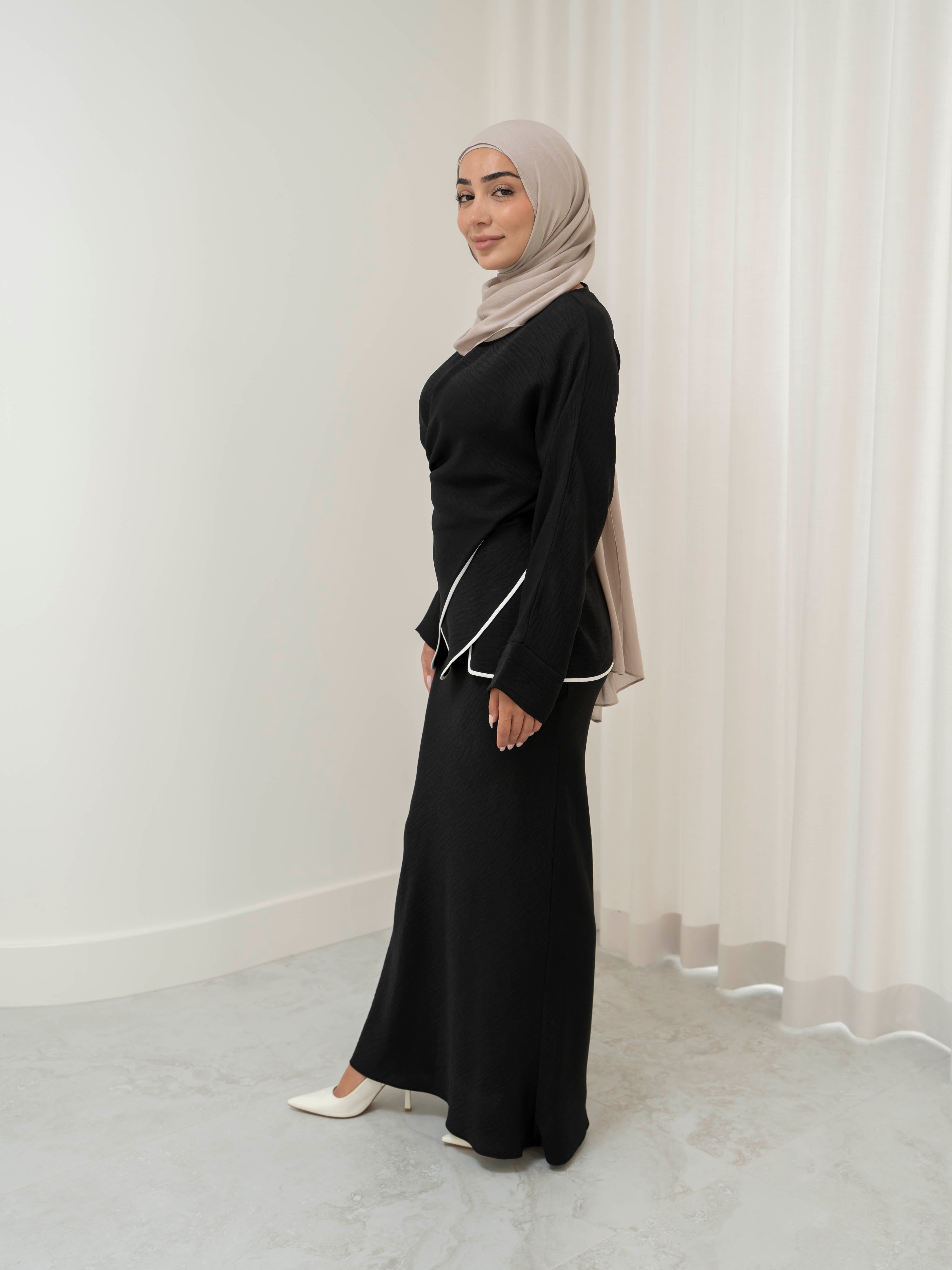 Sienna Wrap Set, a two-piece outfit with a wrap-style tie top featuring contrast piping and long sleeves, paired with a full-length flowing skirt. Lightweight fabric drapes elegantly for a modest, refined silhouette suitable for Eid, special occasions, or versatile everyday wear.