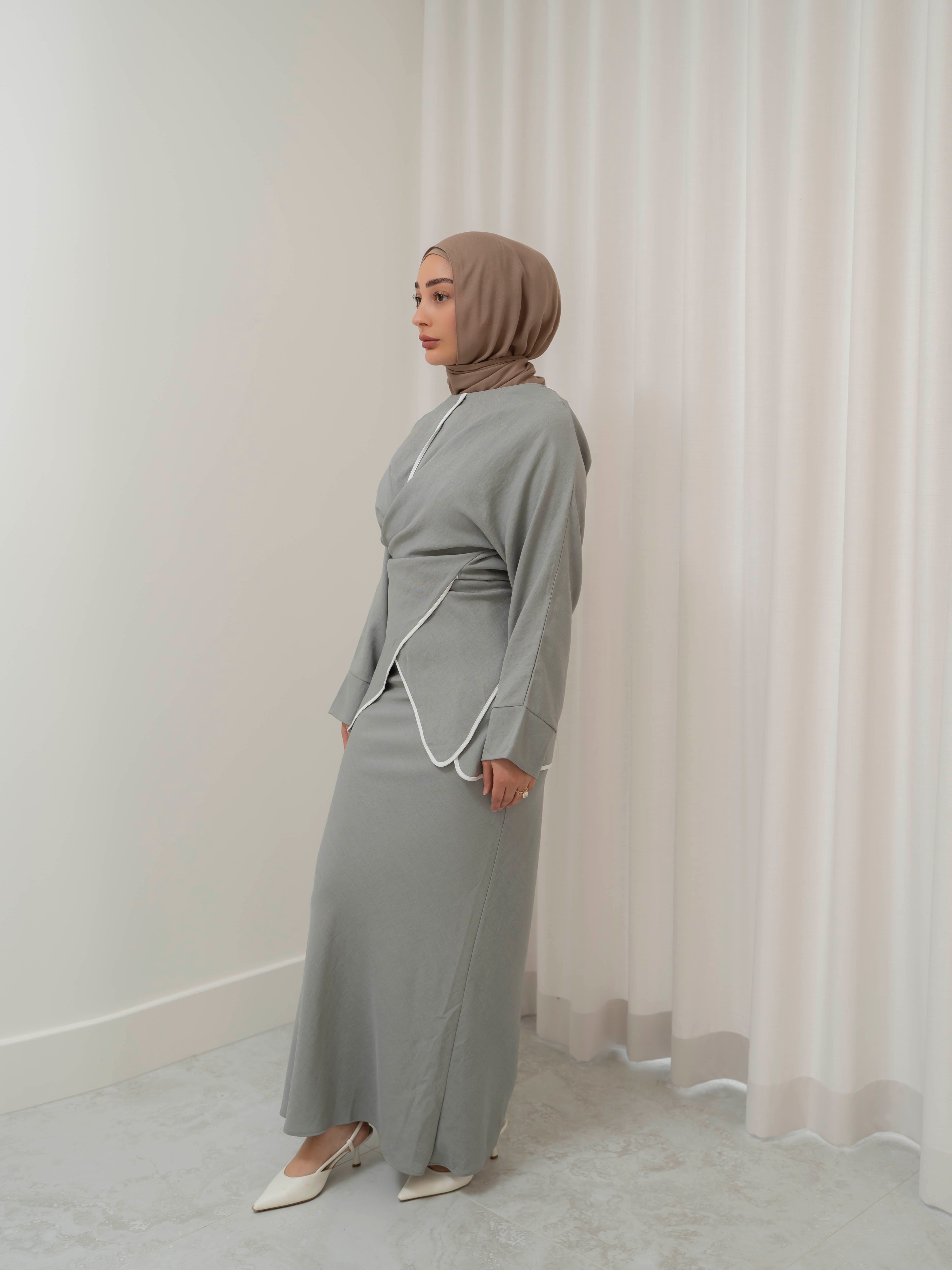 Sienna Wrap Set, a two-piece outfit with a wrap-style tie top featuring contrast piping and long sleeves, paired with a full-length flowing skirt. Lightweight fabric drapes elegantly for a modest, refined silhouette suitable for Eid, special occasions, or versatile everyday wear.