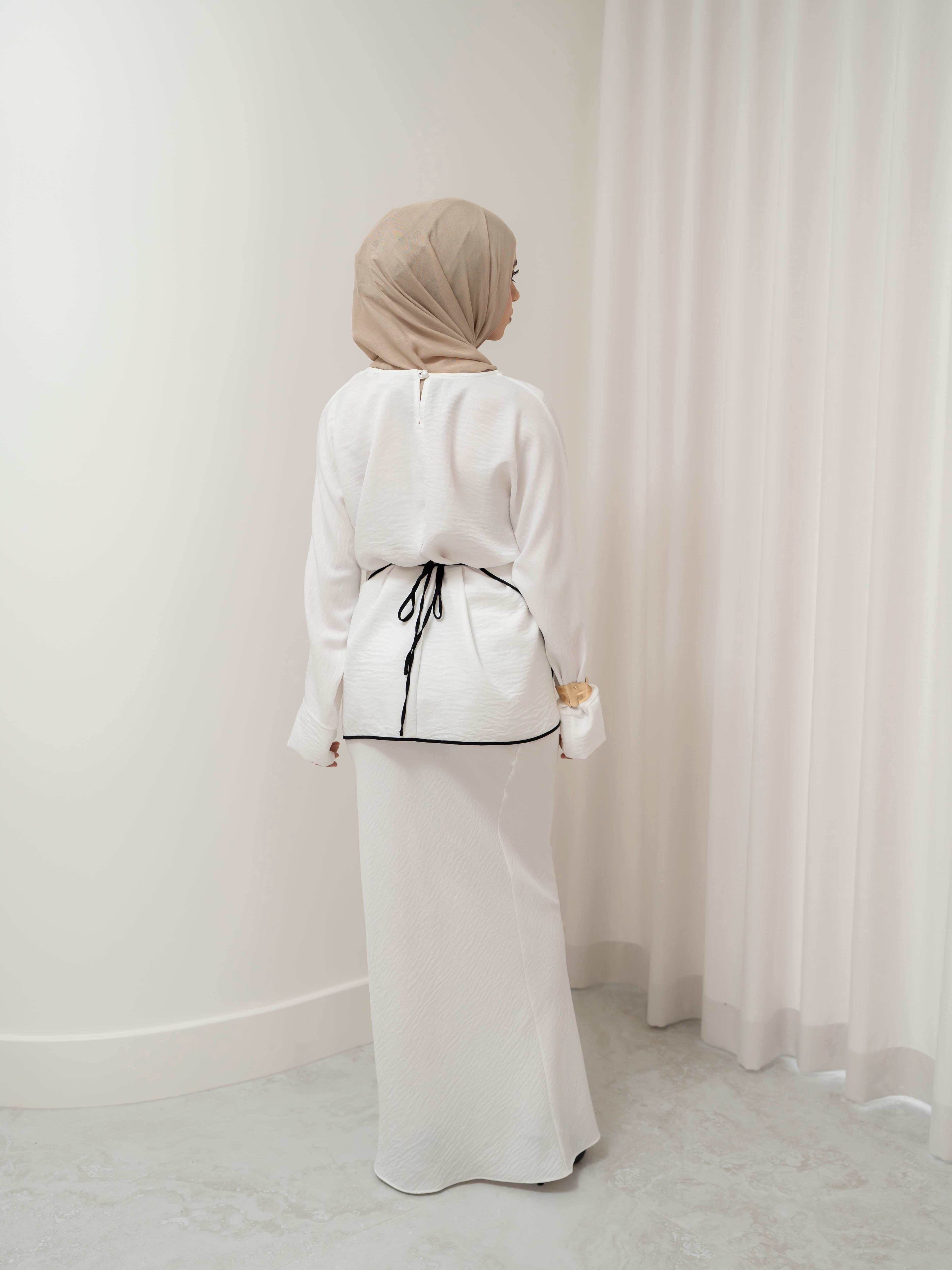 Sienna Wrap Set, a two-piece outfit with a wrap-style tie top featuring contrast piping and long sleeves, paired with a full-length flowing skirt. Lightweight fabric drapes elegantly for a modest, refined silhouette suitable for Eid, special occasions, or versatile everyday wear.