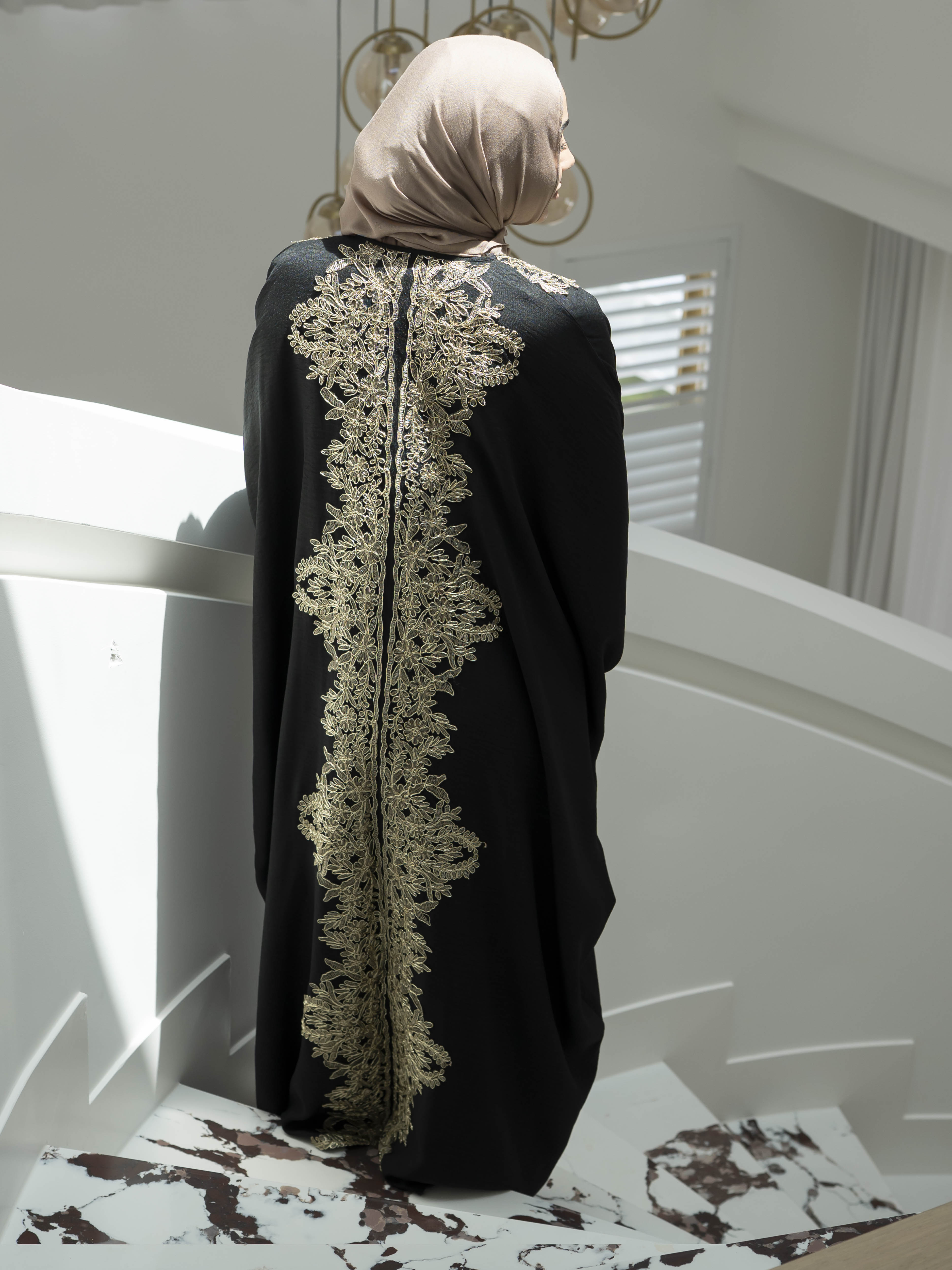 Sultanah Abaya with flowing silhouette and intricate gold embroidery, designed for elegant, modest formal wear. Features delicate gold detailing for a refined, regal finish and includes a sleeveless inner dress for comfortable layering. Perfect for Eid, special occasions, and formal gatherings.