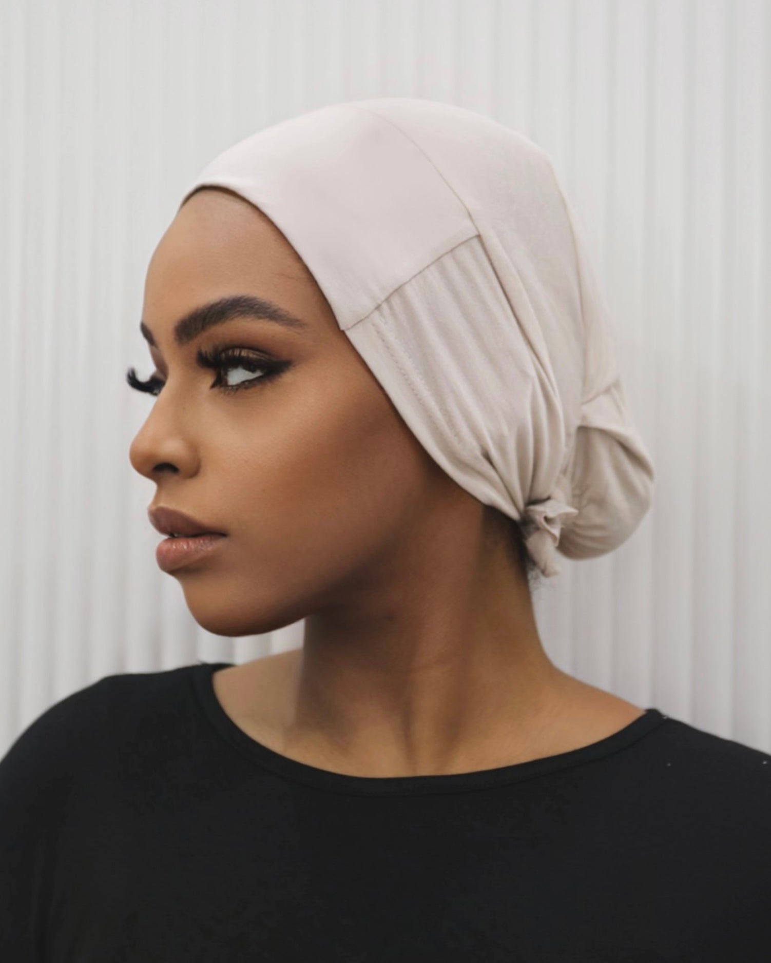 Tie Back Cap in Nude colour, featuring an adjustable strap at the back for a comfortable fit.