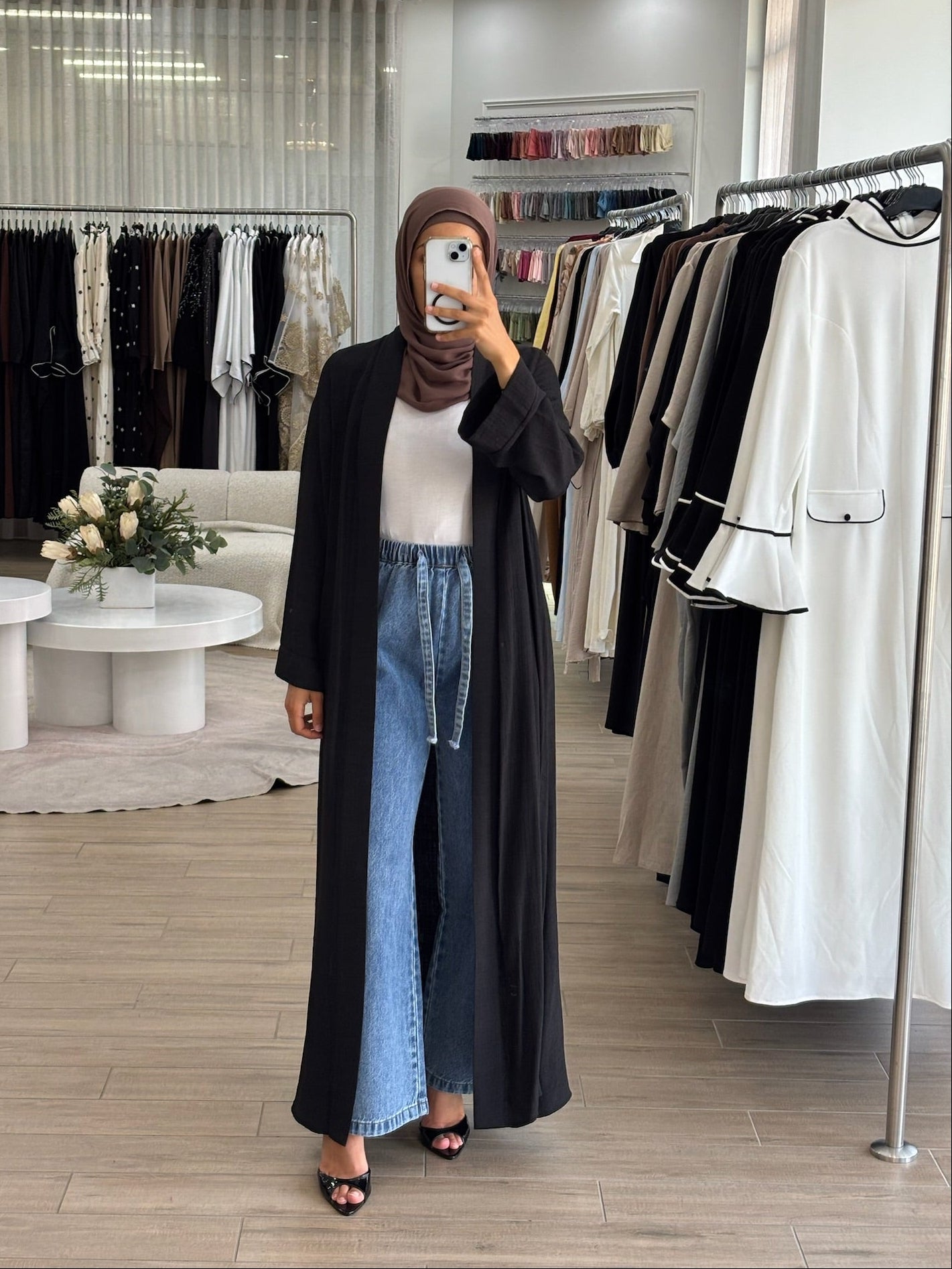 Woman wearing a long lightweight open kimono in black, featuring a flowing longline silhouette and relaxed fit.