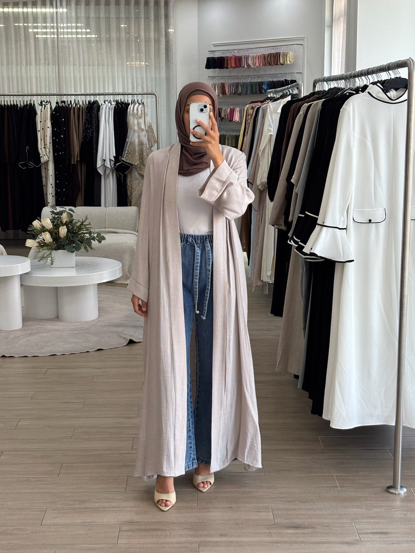 Woman wearing a long lightweight open kimono in stone, featuring a flowing longline silhouette and relaxed fit.