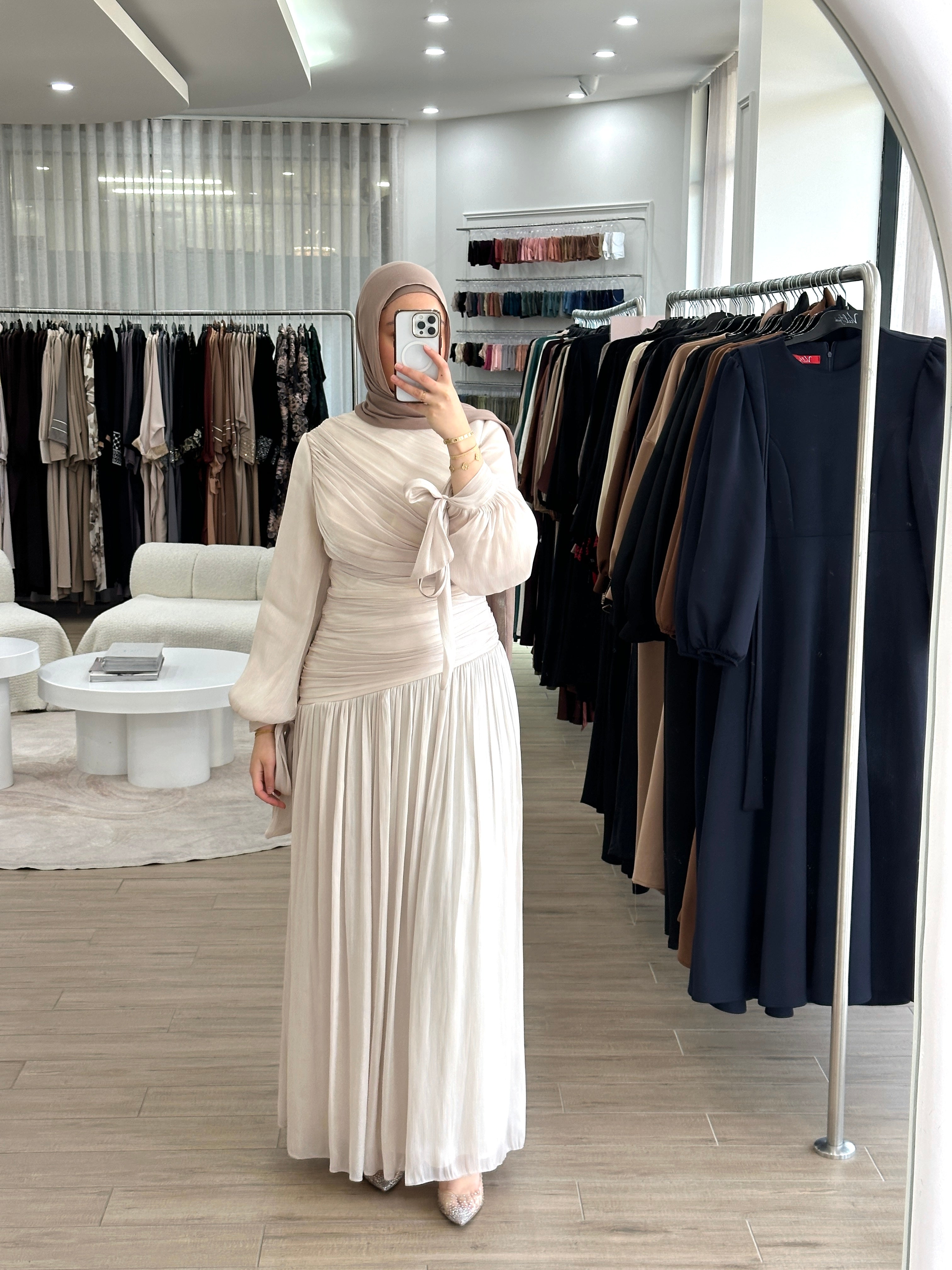 Manelle Formal Dress in shimmery fabric with ruched pleats, fitted asymmetric bodice, and gathered maxi-length skirt. Features long draped balloon sleeves with tie cuffs and full lining, combining elegant style with comfortable wear for formal occasions.