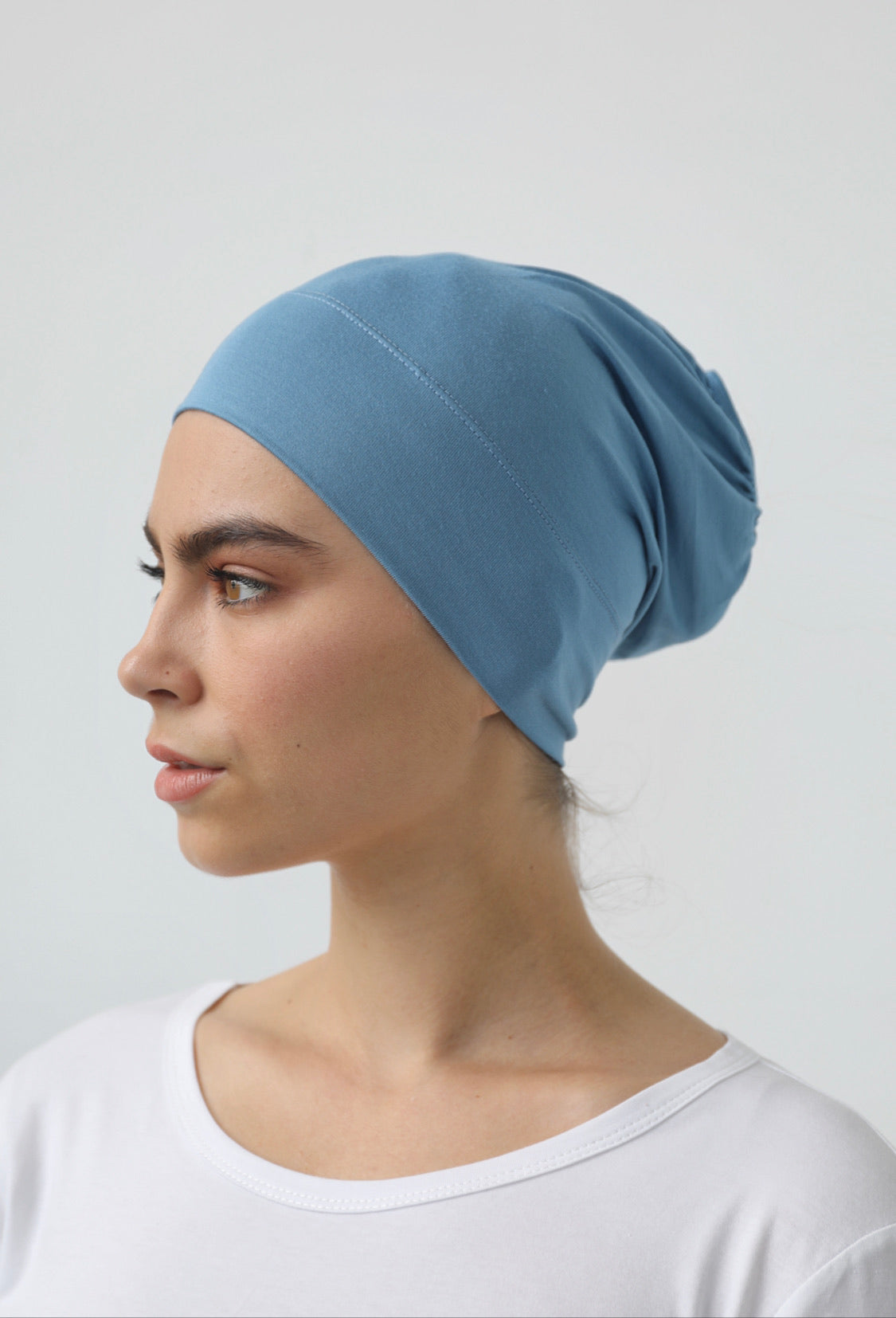 Bamboo under-scarf cap designed to cover hair beneath a hijab, made from soft, breathable natural bamboo fibers with cotton spandex stretch for comfort. Partially closed at the back with an elastic edge to comfortably accommodate hair.