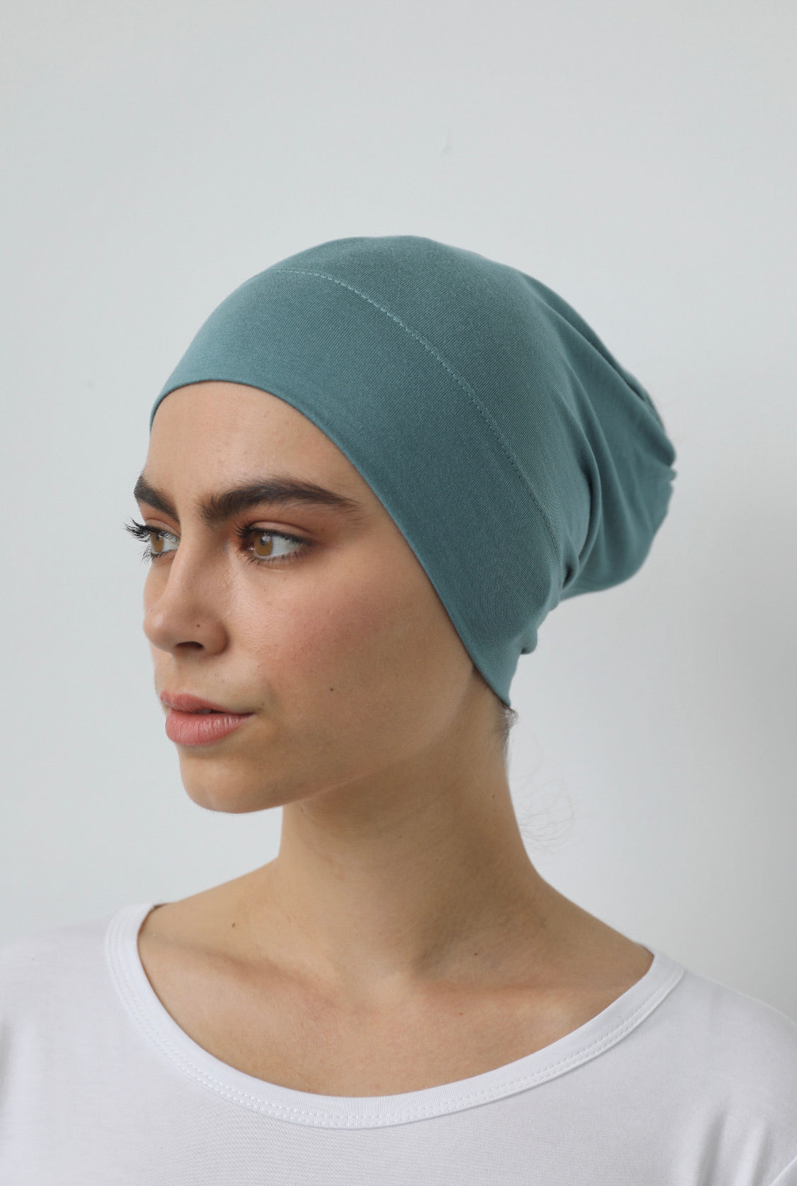 Bamboo under-scarf cap designed to cover hair beneath a hijab, made from soft, breathable natural bamboo fibers with cotton spandex stretch for comfort. Partially closed at the back with an elastic edge to comfortably accommodate hair.