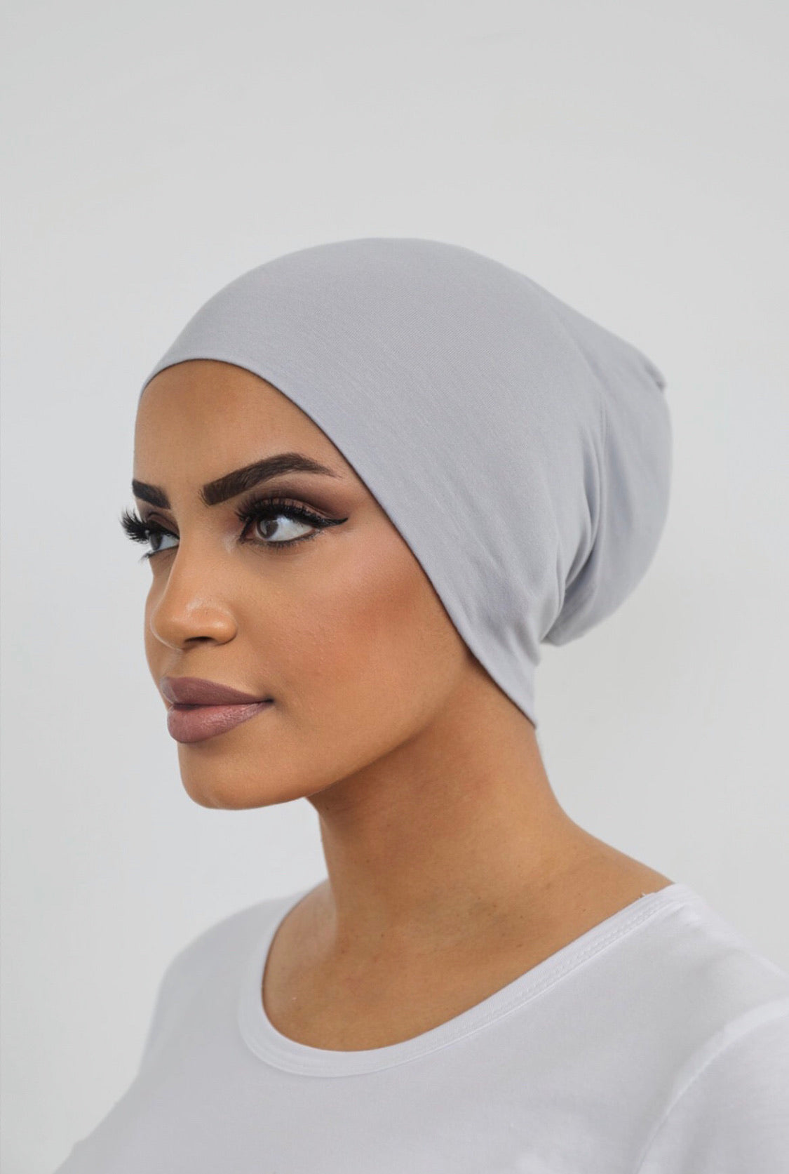 Bamboo under-scarf cap designed to cover hair beneath a hijab, made from soft, breathable natural bamboo fibers with cotton spandex stretch for comfort. Partially closed at the back with an elastic edge to comfortably accommodate hair.