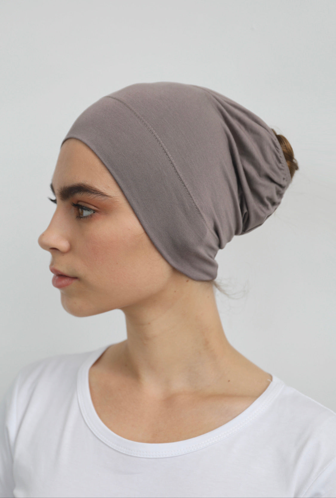 Bamboo under-scarf cap designed to cover hair beneath a hijab, made from soft, breathable natural bamboo fibers with cotton spandex stretch for comfort. Partially closed at the back with an elastic edge to comfortably accommodate hair.